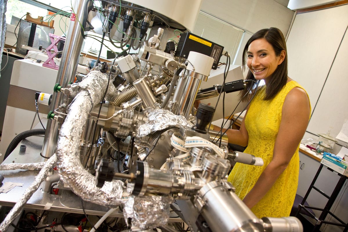A scanning probe instrument in a materials laboratory, its sample stage lit by a single lamp